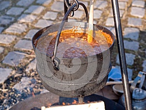 Cooking soup over burning campfire