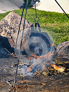 Cooking soup over burning campfire