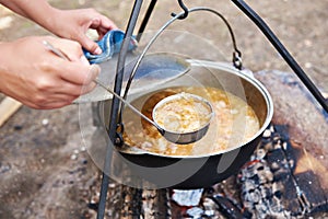 Cooking soup over campfire in hike