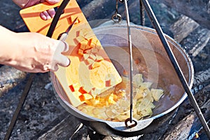 Cooking soup in the stowed bowler over campfire