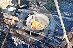 Cooking soup in the stowed bowler over campfire