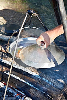 Cooking soup in the stowed bowler over campfire