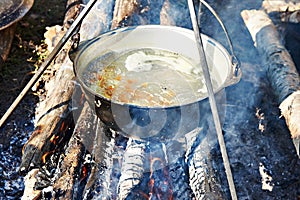 Cooking soup in the stowed bowler over campfire