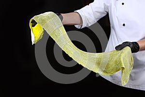 Cooking spaghetti dough with spinach. Healthy food. Organic food. Unrecognizable person. Black background. Machine for making