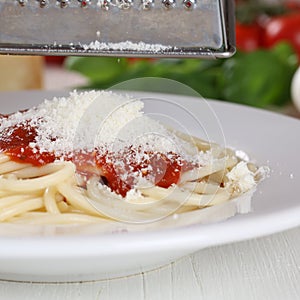 Cooking spaghetti noodles pasta grating Parmesan cheese on plate photo