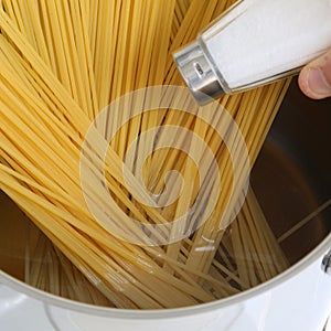 Cooking spaghetti noodles pasta meal salting water in the pot photo