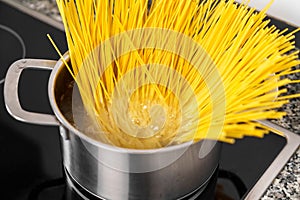 Cooking spaghetti in a pot of boiling water