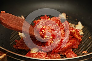 Cooking spicy meat with tomato dip by chef.