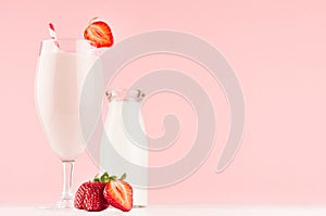 Cooking of spring fresh pink milkshake with strawberry, bootle of milk on soft pink background, copy space.