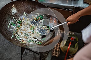 cooking stirring indonesian fried rice in the wok