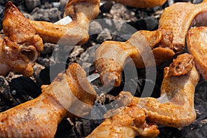 Cooking during summer picnic - appetizing juicy chicken barbecue on outdoors metal skewers on charcoal grill with fire smoke