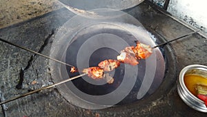 Cooking tandoori chicken in fire flame