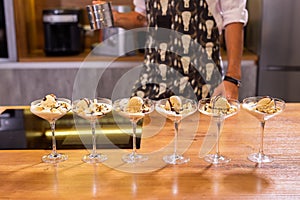 Cooking tasty ice cream dessert made from chocolate and vanilla in glass bowl