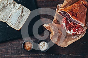 Cooking tasty panini with ham covered with cheese, tomatoes and flavoring