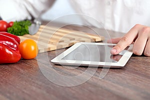 Cooking, technology and home concept - closeup of man pointing finger to tablet pc computer