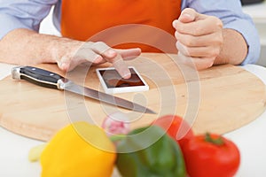 Cooking, technology and home concept - man pointing finger to smartphone closeup.