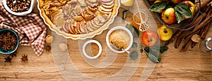 Cooking Thanksgiving autumn apple pie with fresh fruits and walnuts on wooden background, top view. Banner