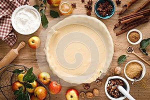 Cooking Thanksgiving autumn apple pie with fresh fruits and walnuts on wooden table