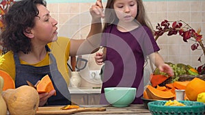 Cooking together for a festive Thanksgiving dinner. Female farmer mother and children cooks pumpkin pie for harvest