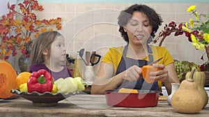 Cooking together for a festive Thanksgiving dinner. Female farmer mother and children cooks pumpkin pie for harvest