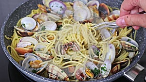 Cooking traditional italian seafood pasta with clams