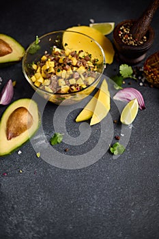 Cooking traditional tuna and mango tartare - chopped and mixed tuna, mango, cilantro and onion in a glass bowl