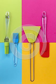 Spatulas and silicone brushes on bright colored geometric background photo