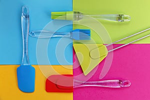 Spatulas and silicone brushes on bright colored geometric background photo