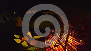 Cooking various street food dishes on a rotating grill over a fire