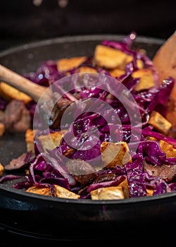 Cooking a vegan Asian Pad Thai stir fry with red cabbage, tofu and noodles.