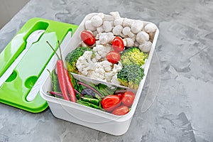 Cooking vegan food with raw vegetables. Broccoli and cauliflower, pepper and champignons for a vegetable dish in a plastic