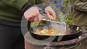 Cooking vegetables with meat outdoors. Fried vegetables in a cauldron. Vacation concepte. 4K