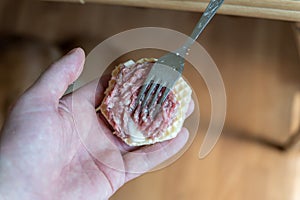 Cooking waffle crusts stuffed with minced meat. Step by step sequence. A man puts the raw stuffing on a waffle crust. Home cooking