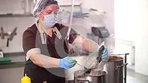 Cooking. woman chef, in protective gloves and mask, prepares food in the kitchen, in canteen. health food. safety