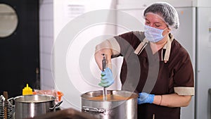 Cooking. woman chef, in protective gloves and mask, prepares food in the kitchen, in canteen. health food. safety