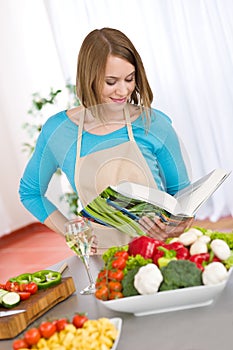 Cooking - Woman reading cookbook in kitchen