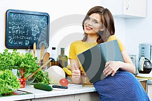 Cooking woman standing in kitchen, reed recipe from menu