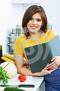 Cooking woman standing in kitchen, reed recipe from menu