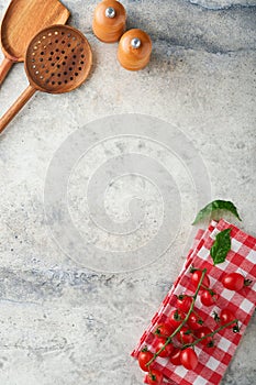 Cooking wooden utensils, basil leaves and spices on old grey background. Abstract food background. Top view of dark rustic kitchen