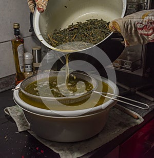 Cooking of yellow and green marijuana butter in hot water in kitchen