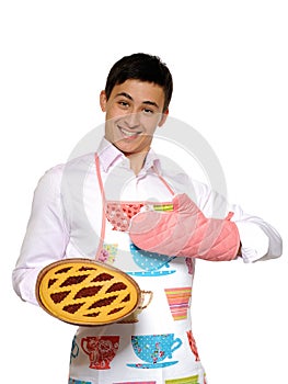 Cooking. Young man in apron baked tasty pie
