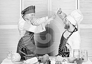 Cooking with your spouse can strengthen relationships. Couple compete in culinary arts. Woman and bearded man culinary