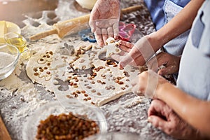 Cooks working at table covered with dough and food supplies