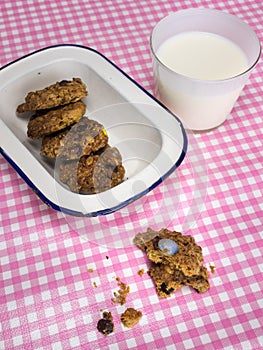 Cooky with milk and dish of cookies on check table cloth