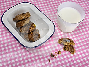 Cooky with milk and dish of cookies on check table cloth photo