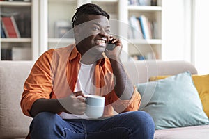 Cool african american man drinking coffee and talking on phone