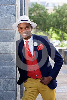 Cool african fashion man in suit leaning against wall