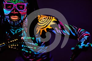 Cool african man with fluorescent body art dancing isolated