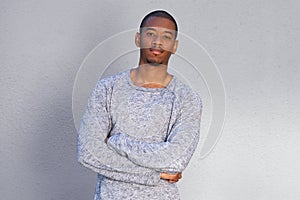Cool african man standing by gray background with arms crossed