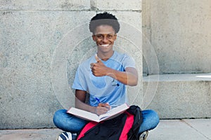 Cool african young adult male student showing thumb up